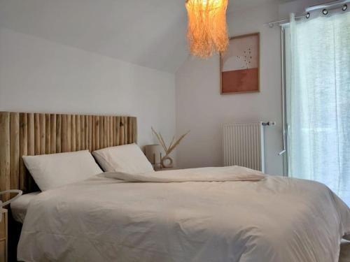 une chambre avec un grand lit et un lustre dans l'établissement Le Chevalier Gambette - Parking gratuit, à Saint-Valery-sur-Somme