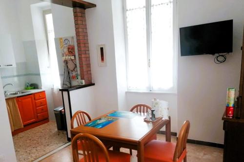 a dining room with a table and chairs and a television at Domo Nina in La Spezia