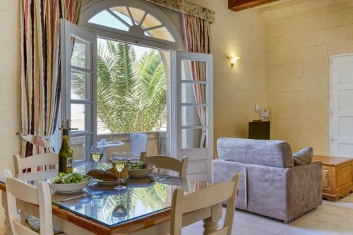a dining room with a table and a window at Villagg tal-Fanal in Għasri