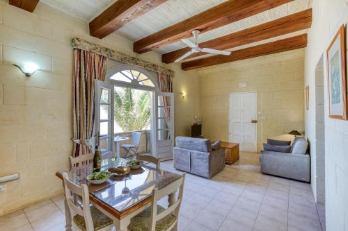 a living room with a ceiling fan and a table at Villagg tal-Fanal in Għasri