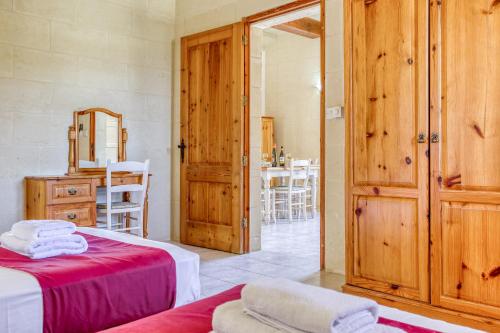 a bedroom with two beds and a table with chairs at Villagg tal-Fanal in Għasri