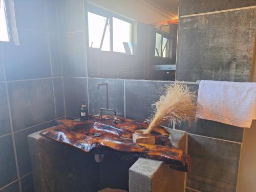 a bathroom with a wooden sink with a faucet at RuaWilla Guest Cottage in Lutzville