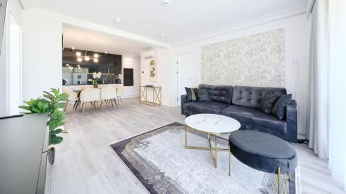 a living room with a blue couch and a table at Sea&Lake, Sun & Snow in Mielno