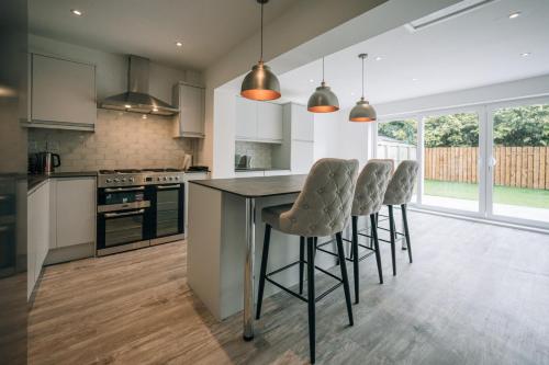a kitchen with a island with bar stools at Wiske House Free Parking & Fast WiFi in Stockton-on-Tees