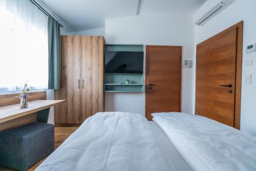 a small bedroom with a bed and wooden cabinets at das Ursprung in Deutschlandsberg