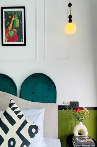 a bedroom with a bed with green chairs and a lamp at Isara Boutique Hotel and Cafe in Phuket Town