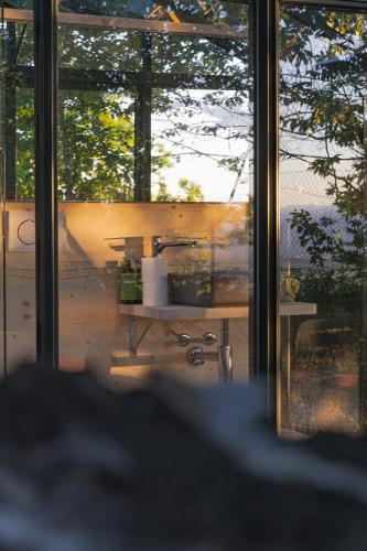 a view of a room with a table and windows at Vivi la Magia di Bisdalù - Dormi nella Stanza nel Bosco, Ammira le Stelle e Rilassati con l'Area Benessere e Colazione in Peveragno