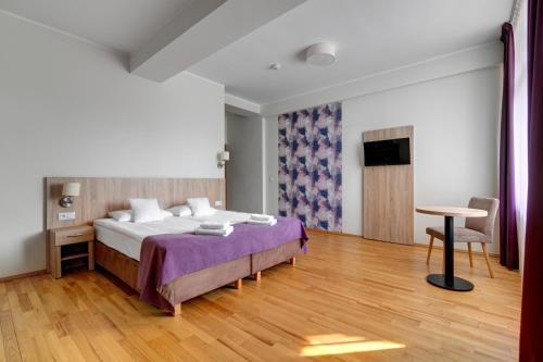 a bedroom with a bed and a desk and a table at Silesia Krynica in Krynica Zdrój