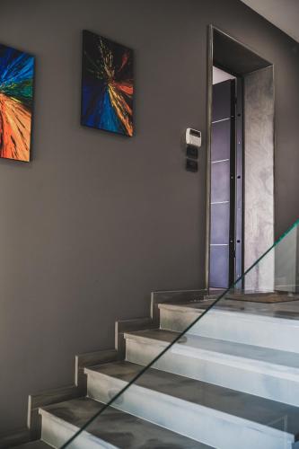a set of stairs with two paintings on the wall at Epirus Hotel in Sarandë