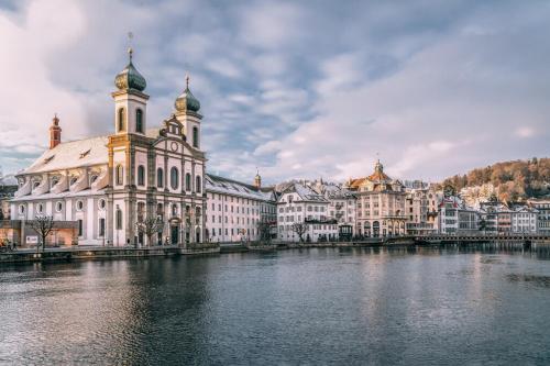 a large building with a clock tower next to a river at NH 6 Interlaken-Luzern I Lake I Mountain I connect in Sachseln