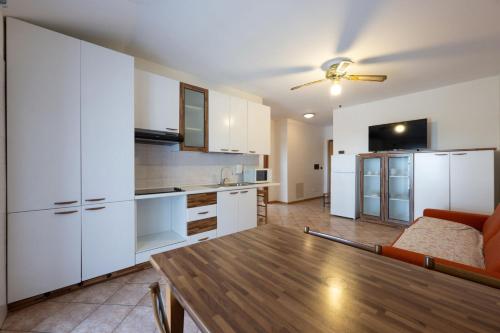a kitchen with white cabinets and a table in a room at Residence Desiree in Riva del Garda