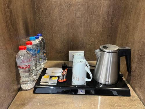 a counter top with a coffee maker and water bottles at Tolip Resort El Galala Heights in Ain Sokhna
