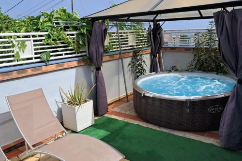 a hot tub on a balcony with a umbrella at Villa Sun and Sea in Deshaies