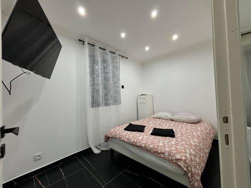 ein Schlafzimmer mit einem Bett mit zwei schwarzen Kissen darauf in der Unterkunft Chaleureux t1 Aiguebelle in Randens