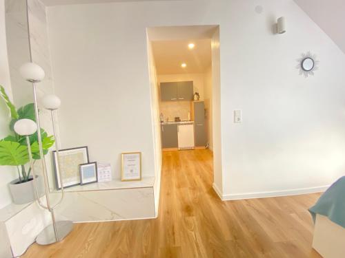 a living room with white walls and a hard wood floor at Lux Apartment near Frankfurt! in Mörfelden-Walldorf