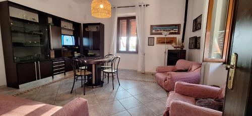 a living room with a table and a kitchen at Casa dei bagnanti sul Porto Vecchio in Stintino