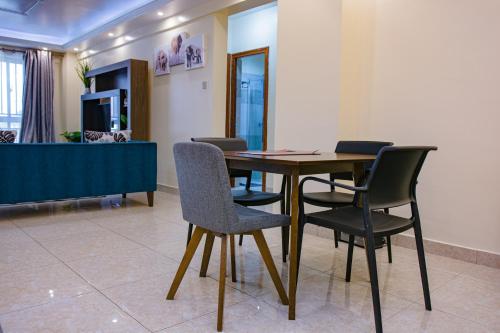 a dining room with a table and chairs at Elegant 2 BR Apartment Kileleshwa - Free Netflix, Parking, Superfast WIFI, Views of Arboretum in Nairobi