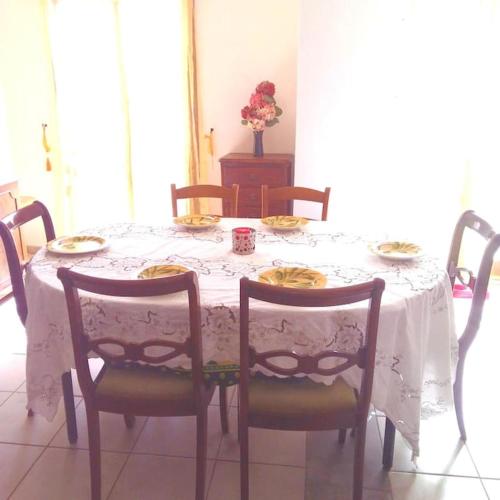 - une table à manger avec une nappe et des chaises blanches dans l'établissement Appartement du bonheur- 6 personnes, à Gruissan