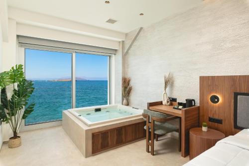 a bedroom with a bathtub and a desk and a bed at Elia Sea Suites in Chania Town