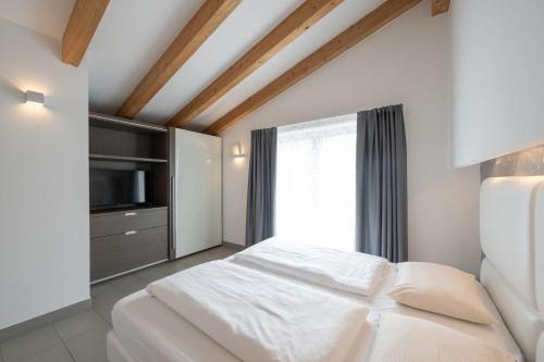a bedroom with a white bed and a television at Residence Desiree in Riva del Garda