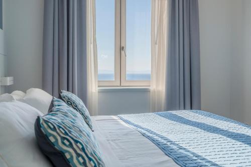 a bedroom with a bed with a window at Lloyd's Baia Hotel in Vietri sul Mare