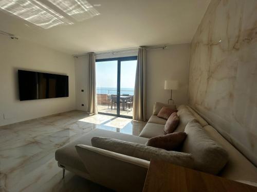 a living room with a couch and a large window at Belvedere Mondial in Moneglia