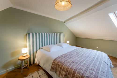 une chambre avec un grand lit dans un grenier dans l'établissement Charmant Duplex au Cœur d'Auxerre, à Auxerre