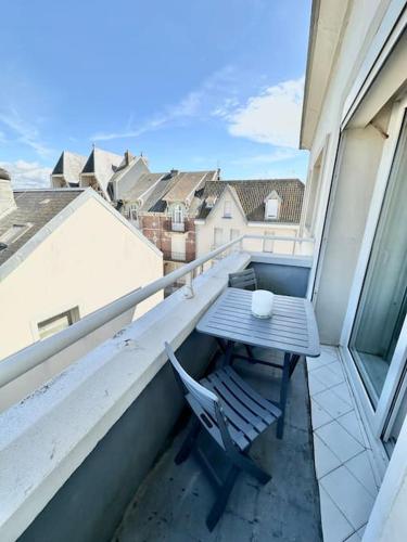 une table et une chaise sur un balcon dans l'établissement Nid douillet - Balcon - Proximité immédiate de la Plage de Berck, à Berck-sur-Mer