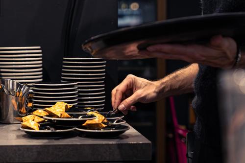 a person eating food on a table with plates at Brit Hotel Confort Manosque Cadarache in Manosque