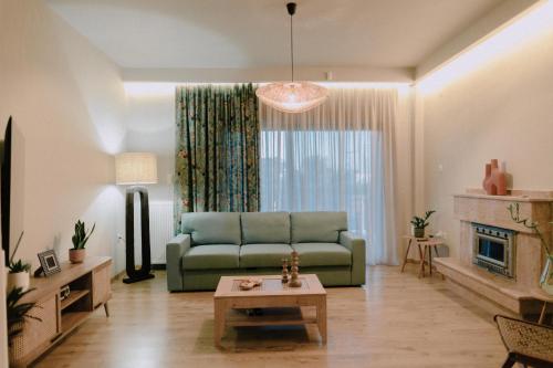 a living room with a green couch and a fireplace at Anassa House in Alexandroupoli