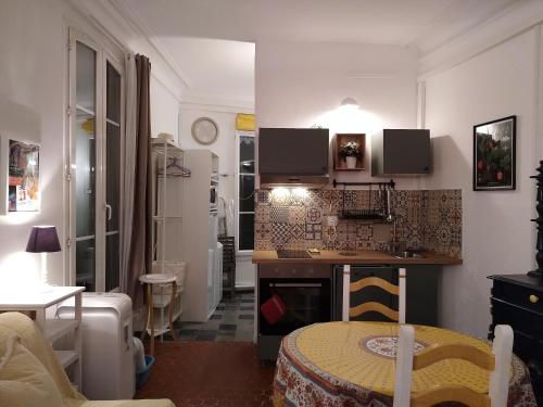 une petite cuisine avec une table dans une pièce dans l'établissement Appartement provençal - Avignon intra-muros, à Avignon