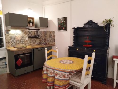 une petite cuisine avec une table et une cuisinière dans l'établissement Appartement provençal - Avignon intra-muros, à Avignon