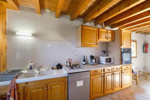 une cuisine avec des armoires en bois et un évier dans l'établissement Chalet Vernay, à Montricher-Albanne