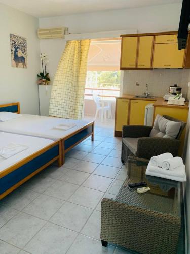 a bedroom with a bed and a kitchen with a table at Hotel Fotini in Mytikas