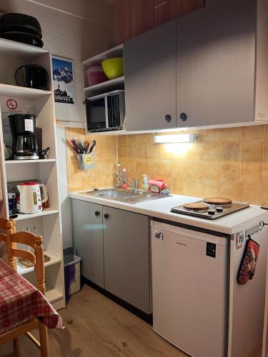 une petite cuisine avec un évier et une cuisinière dans l'établissement Studio panoramique Notre-Dame-de-Bellecombe - 20 m² - balcon sud, à Notre-Dame-de-Bellecombe