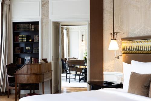 a bedroom with a bed and a piano and a dining room at La Réserve Paris Hotel & Spa in Paris