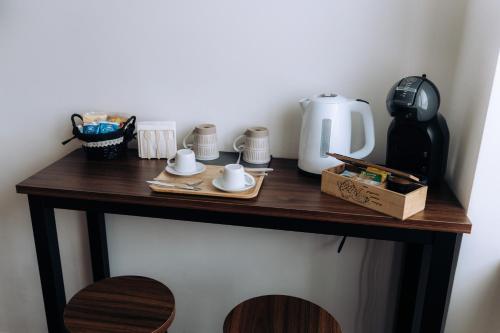 a table with a coffee maker and cups on it at Sleep & Fly Malpensa in Case Nuove