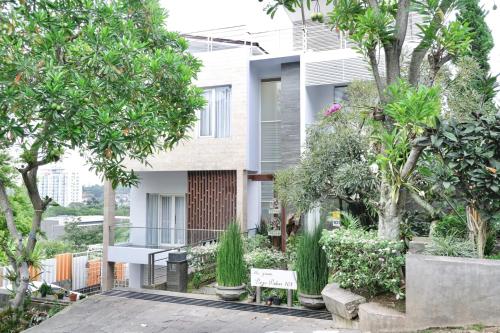 a balcony with a table and trees in front of a building at The Green Wowi Torto, 5 BR, swimming pool in Bandung