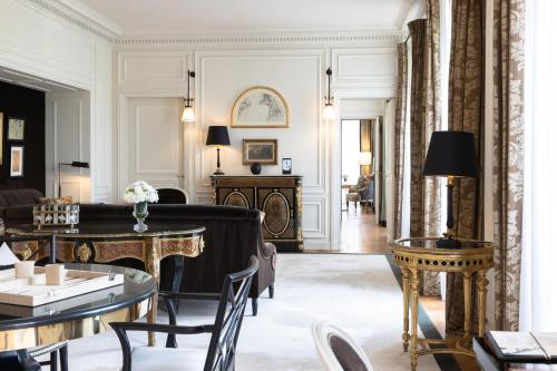 a living room with a couch and tables at La Réserve Paris Hotel & Spa in Paris