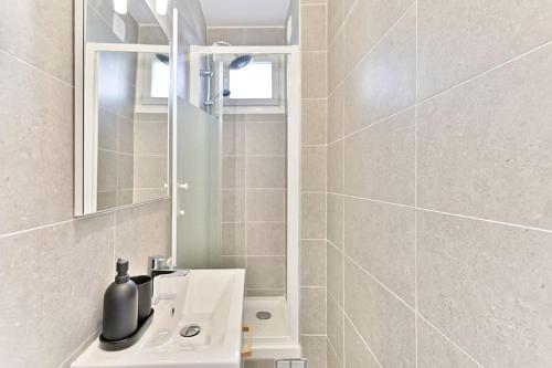 une salle de bain avec un lavabo et un miroir dans l'établissement Havre de paix spacieux en banlieue Parisienne, à Montreuil