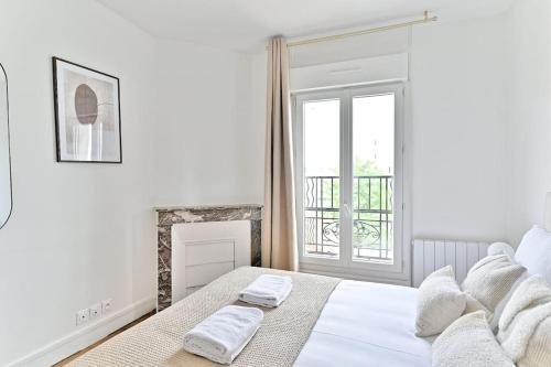 une chambre blanche avec un lit et une cheminée dans l'établissement Havre de paix spacieux en banlieue Parisienne, à Montreuil