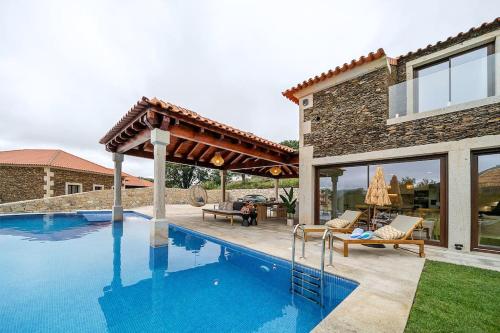 a swimming pool in the backyard of a house at Oliveiral Villa with River View, Heated Pool & Jacuzzi in Vila Nova de Cerveira
