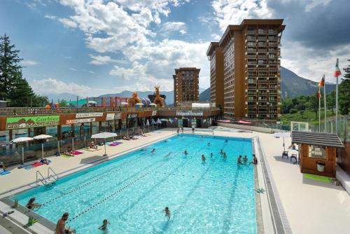 - une grande piscine avec des personnes dans l'établissement Au Pied Des Pistes Le Corbier 73, à Villarembert