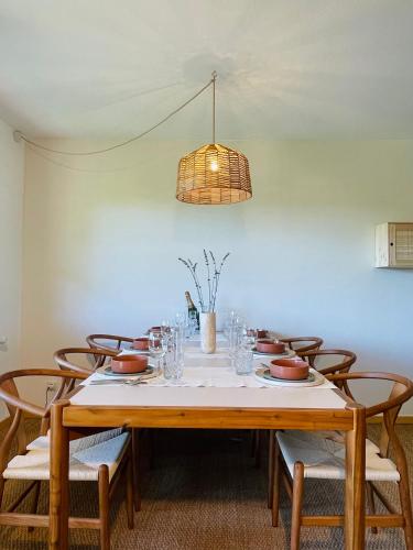 a dining room table with chairs and a light fixture at Natur-Retreat am Leitgeringer See in Tittmoning