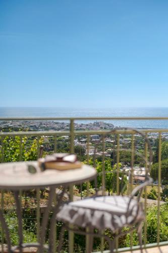 a balcony with a table and chairs and the beach at Poggio Del Sole in Ischia