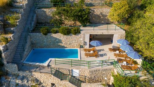 an overhead view of a swimming pool with lounge chairs and a pool at Apartments with pool Maraska in Brela