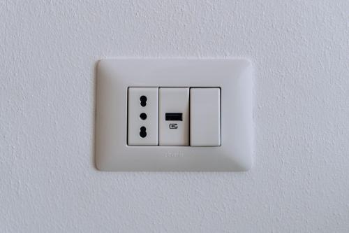 a white light switch on a white wall at Sleep & Fly Villa Luisa in Case Nuove