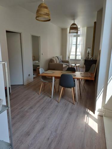 un salon avec une table et des chaises en bois dans l'établissement Appartement T2 50m2 Site remarquable, à Lons-le-Saunier