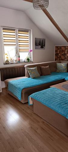 two beds sitting in a room with two windows at Apartman Denis Una in Lužine