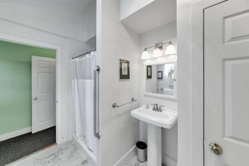 a white bathroom with a sink and a shower at Bear Pass - Mountain View home in Sunderland